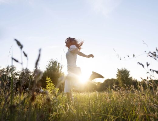 Kobieta, która ma dużo energii biegająca po łące